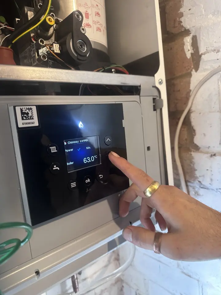 Engineer carrying out commissioning checks on a boiler control panel